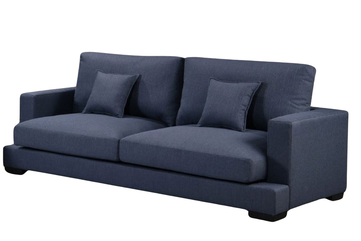 Sofá azul con brazos y con dos cojines sobre un fondo blanco.